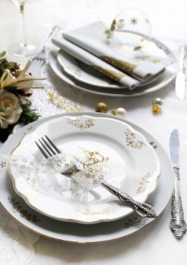 Zarif ve şenlikli bir ortam, Noel masası için mükemmel, beyaz, altın ve gümüş-gri renklerle. Mücevherlerle süslenmiş Noel süslemeleri, mermer mumlar. Noel ve tatil sezonu.