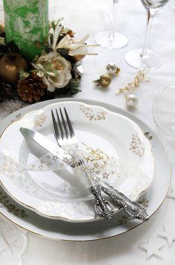 Zarif ve şenlikli bir ortam, Noel masası için mükemmel, beyaz, altın ve gümüş-gri renklerle. Mücevherlerle süslenmiş Noel süslemeleri, mermer mumlar. Noel ve tatil sezonu.