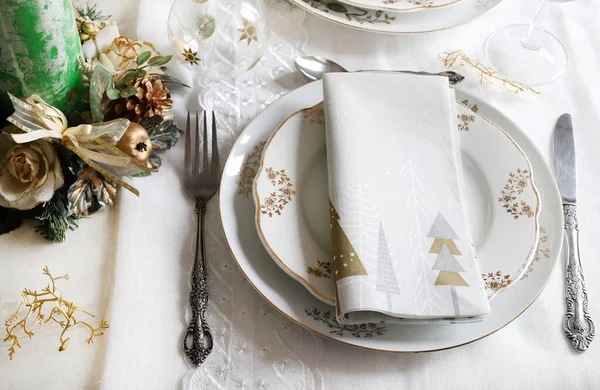 Zarif ve şenlikli bir ortam, Noel masası için mükemmel, beyaz, altın ve gümüş-gri renklerle. Mücevherlerle süslenmiş Noel süslemeleri, mermer mumlar. Noel ve tatil sezonu.