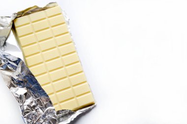 Beyaz arka planda izole edilmiş folyo ambalajlı beyaz çikolata. Genel bakış. Boşluğu kopyala.