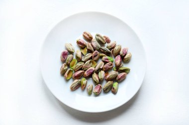 Beyaz arka planda beyaz bir tepsi kabuklu fıstık. Sağlıklı ve vejetaryen kuru yiyecekler. Genel bakış. Boşluğu kopyala.