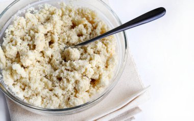 Klasik İtalyan hamur parçaları, sbrisolona olarak da bilinir, beyaz arka planda izole edilmiş bir kaşıkla cam bir kasede. Genel Görünüm.