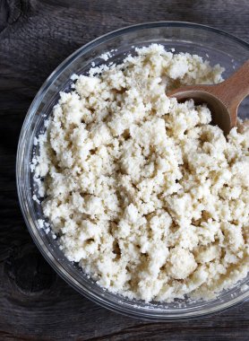 Klasik İtalyan hamur parçaları, sbrisolona olarak da bilinir, tahta bir arka planda izole edilmiş tahta kaşıkla cam bir kasede. Genel Görünüm.