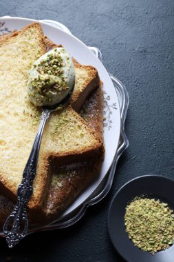 Fıstık dolu Pandoro. Klasik İtalyan Noel pastasının bir çeşidi dilimlenmiş ya da bütün olarak servis edilmiş ve üzerinde fıstık ezmesi ve krema ile kaplı. Noel ve Yeni Yıl gelenekleri. Koyu arkaplan.
