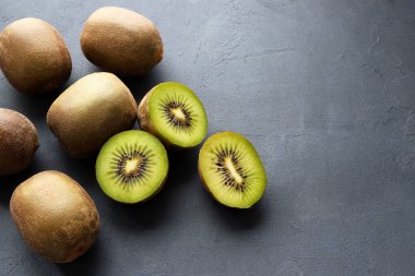 Yeşil kivi meyvesi. Siyah arka planda izole edilmiş bir tabakta taze ve yarım kivi meyvesi. Sağlıklı meyve.