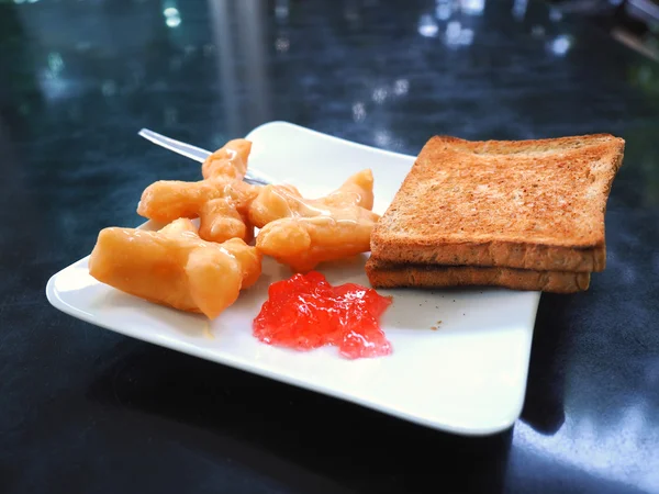 Ontbijt met gefrituurde deeg stick of Patongko met Sweetened gecondenseerde melk en toast met aardbeienjam — Stockfoto