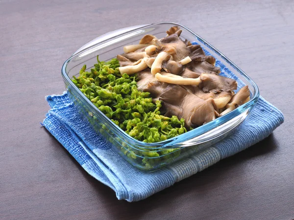 haşlanmış istiridye mantar ve çiçeği sarmaşık kase temizleyin ve mavi masa örtüsü yerleştirildi