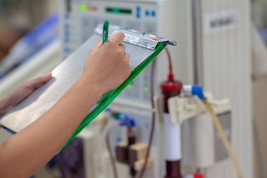 Uzman, sürekli renal yenileme terapi ekipmanlarını, enjeksiyon pompasını ve hemodiyaliz makinesini kontrol ediyor..