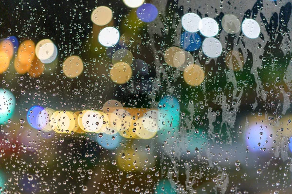 Pencereye yağmur yağdı. Pencereden Bokeh gibi ışık geçerken.
