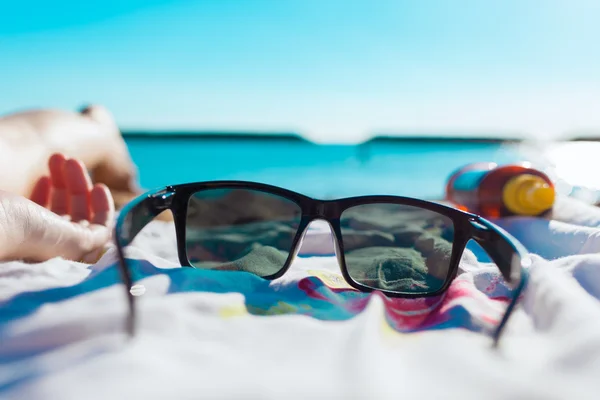 Zonnebril op het strand — Stockfoto