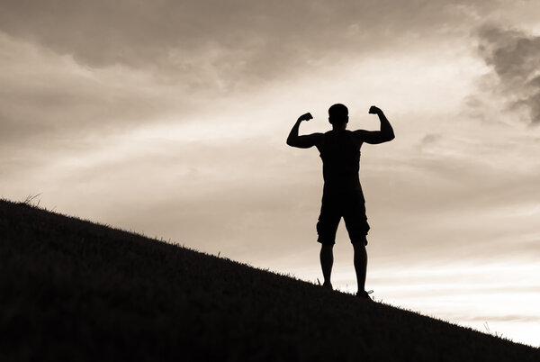 Male flexing on a hill.