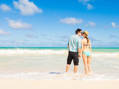 Kumsalda öpüşen çift.