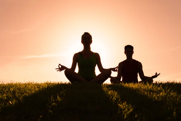 Paar mediteren in het park — Stockfoto