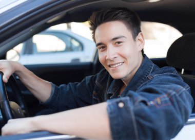 Genç adam araba kullanıyor.