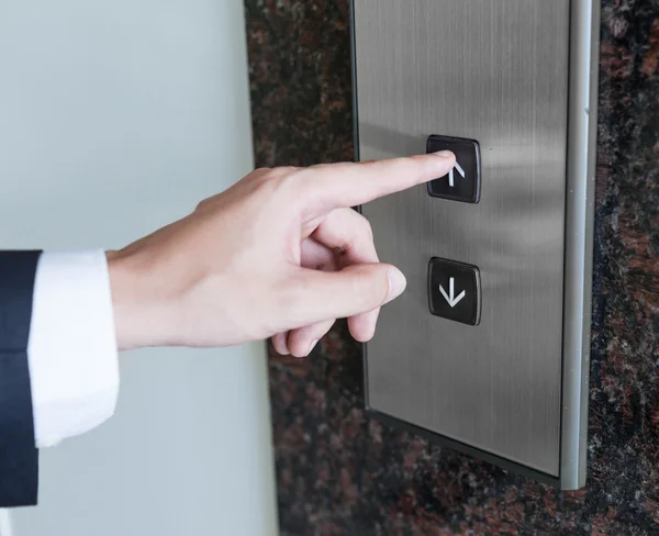 Человек нажимает кнопку лифта — стоковое фото