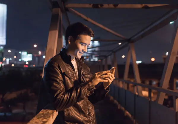 Jeune homme utilisant son téléphone portable Photo De Stock
