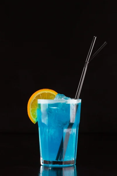 Blauer Cocktail mit Eis, Orange und Strohhalmen — Stockfoto