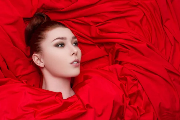 Bela menina glamourosa em pano vermelho — Fotografia de Stock