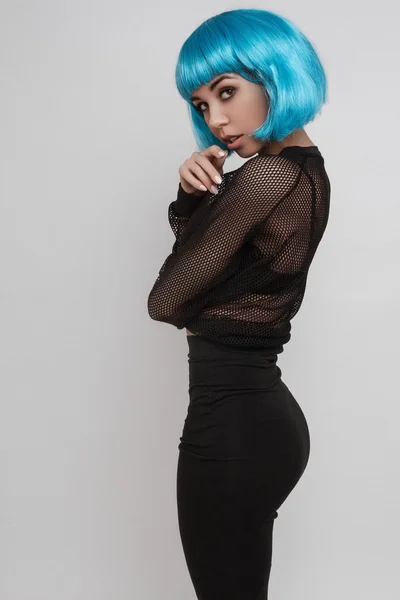 Hermosa chica en una peluca azul de pie en una pose —  Fotos de Stock