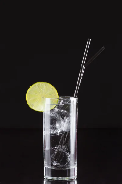 Gin and tonic in the elongated glass with a straw — Stock Photo, Image