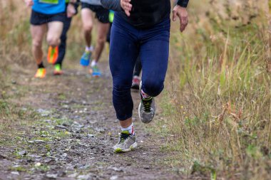 Leading runner leads group athletes to running trail uphill