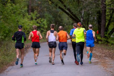 Arka plan grup koşucuları şehir parkında koşmak için amatörler
