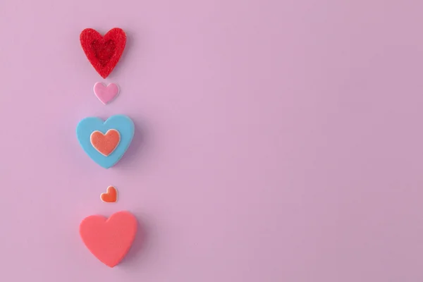 pembe bir arka plan üzerinde çok renkli kalpler çok