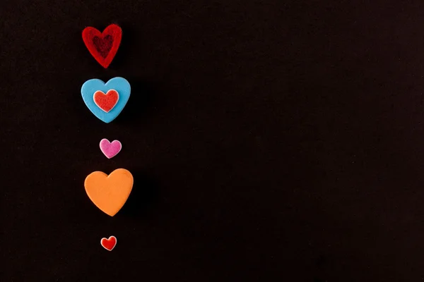siyah bir zemin üzerine çok renkli kalpler çok