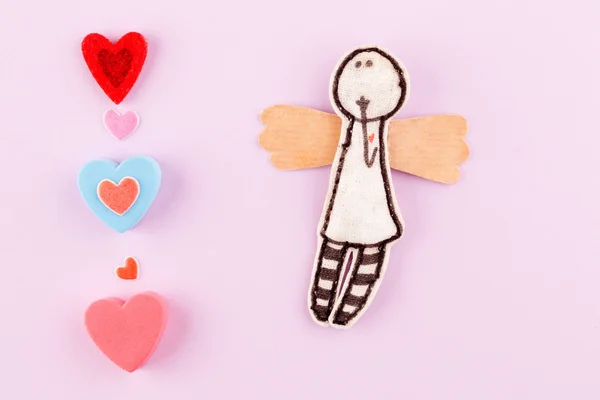 Pembe bir arka plan üzerinde çok renkli kalpler ile kağıt melek