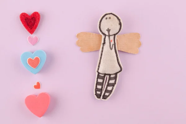 Pembe bir arka plan üzerinde çok renkli kalpler ile kağıt melek