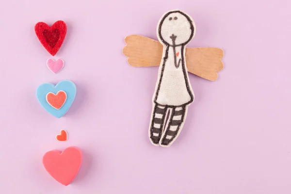 Pembe bir arka plan üzerinde çok renkli kalpler ile kağıt melek