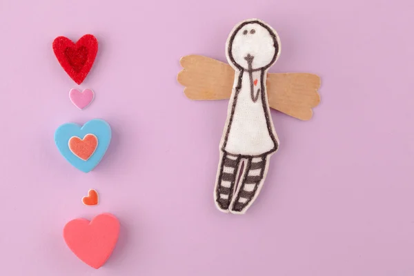 Pembe bir arka plan üzerinde çok renkli kalpler ile kağıt melek