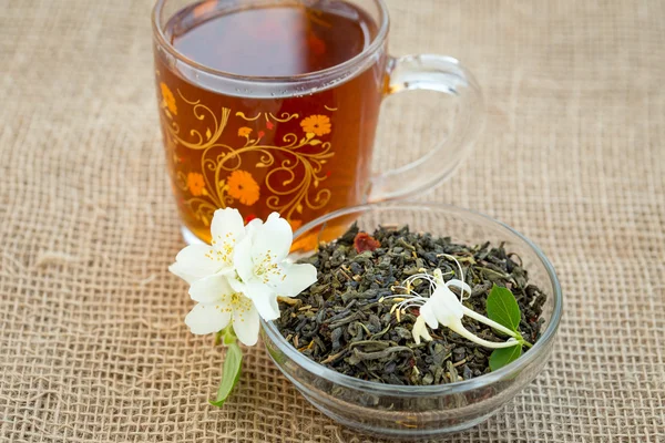 Tazza di tè e tè verde secco con fiori di gelsomino — Foto Stock