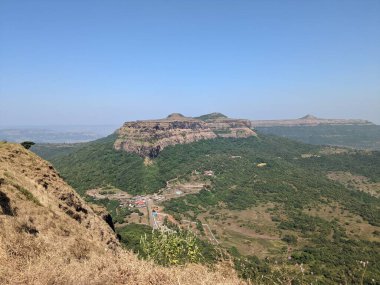 Büyük bir uçurumun eteğinde yerleşmiş bir köyle dağlık bir arazinin nefes kesici manzarası..