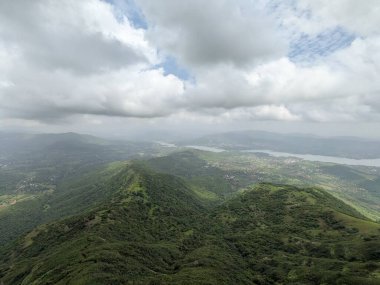 Muson mevsiminde yeşil tepelerin panoramik görüntüsü Sahyadris 'teki manzaranın üzerinde kara bulutlar beliriyor..