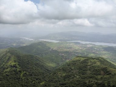 Muson mevsiminde yeşil tepelerin panoramik görüntüsü Sahyadris 'teki manzaranın üzerinde kara bulutlar beliriyor..