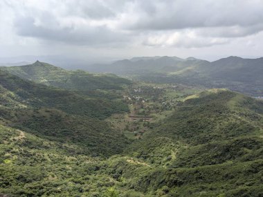 Muson mevsiminde yeşil tepelerin panoramik görüntüsü Sahyadris 'teki manzaranın üzerinde kara bulutlar beliriyor..