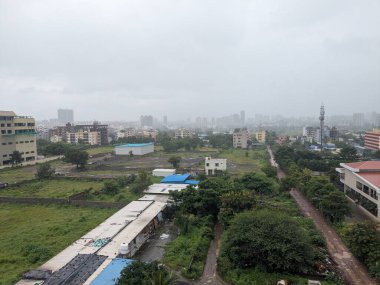 Yumuşak dalgalı sakin bir göl manzarası, yeşil kıyı şeridi bitki örtüsü ve bulutlu bir gökyüzünün altındaki uzak tepeler, doğal ışık altında su kenarından fotoğraflanmış..