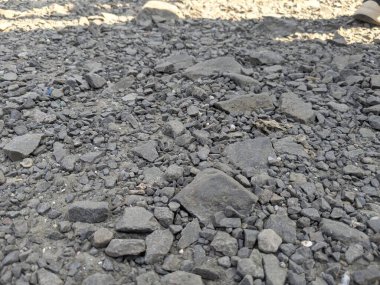 Gevşek taşlar ve çakıllarla kaplı kayalık yolun detaylı görüntüsü