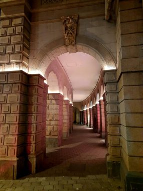 Kemerli kolonların ve sıcak yapay ışıklandırmanın olduğu taş koridor gece görüşü