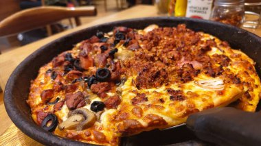 Erimiş peynir ve malzemeyi gösteren tek bir dilim pizza kaldırıldı.