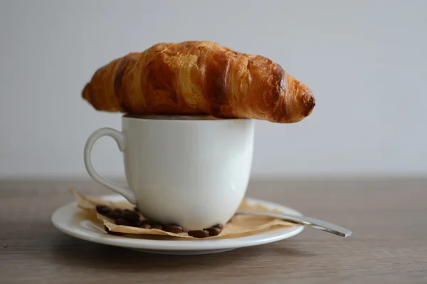 Croissant sur tasse de café — Photo