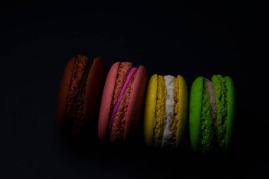 Siyah arkaplanı olan çok renkli makaronlar.