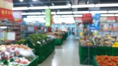 Bulanık süpermarket koridoru taze ürünlerle dolu. Özgeçmiş veya tüketici eğilimlerini göstermek için mükemmel.