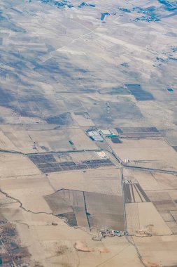 Dağılmış yeşil ekili araziler, sulama kanalları ve araziye yayılmış kırsal çiftlik binaları ile tarımsal kuru arazi manzarası.