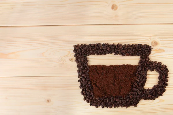 木製の背景に豆からコーヒー カップ — ストック写真