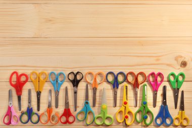 Ahşap arka plan üzerinde çocuklar için parlak makas