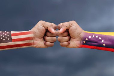 ABD - VENEZUELA savaş ya da çatışma konsepti geçmişi. ABD ve VENEZUELA 'nın boyanmış bayraklarıyla erkeklerin yumrukları.