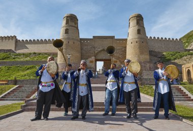 HISSAR,TAJIKISTAN-MARCH 15,2016: The musicians in national costumes welcome guests to Hissar fortress clipart