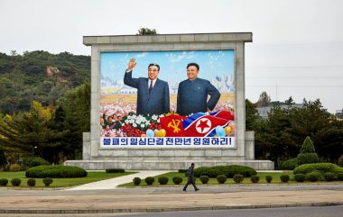 Pyongyang Caddesi 'nde Kuzey Koreli liderler Kim Il Sung ve Kim Jong Il' i gösteren bir panel..